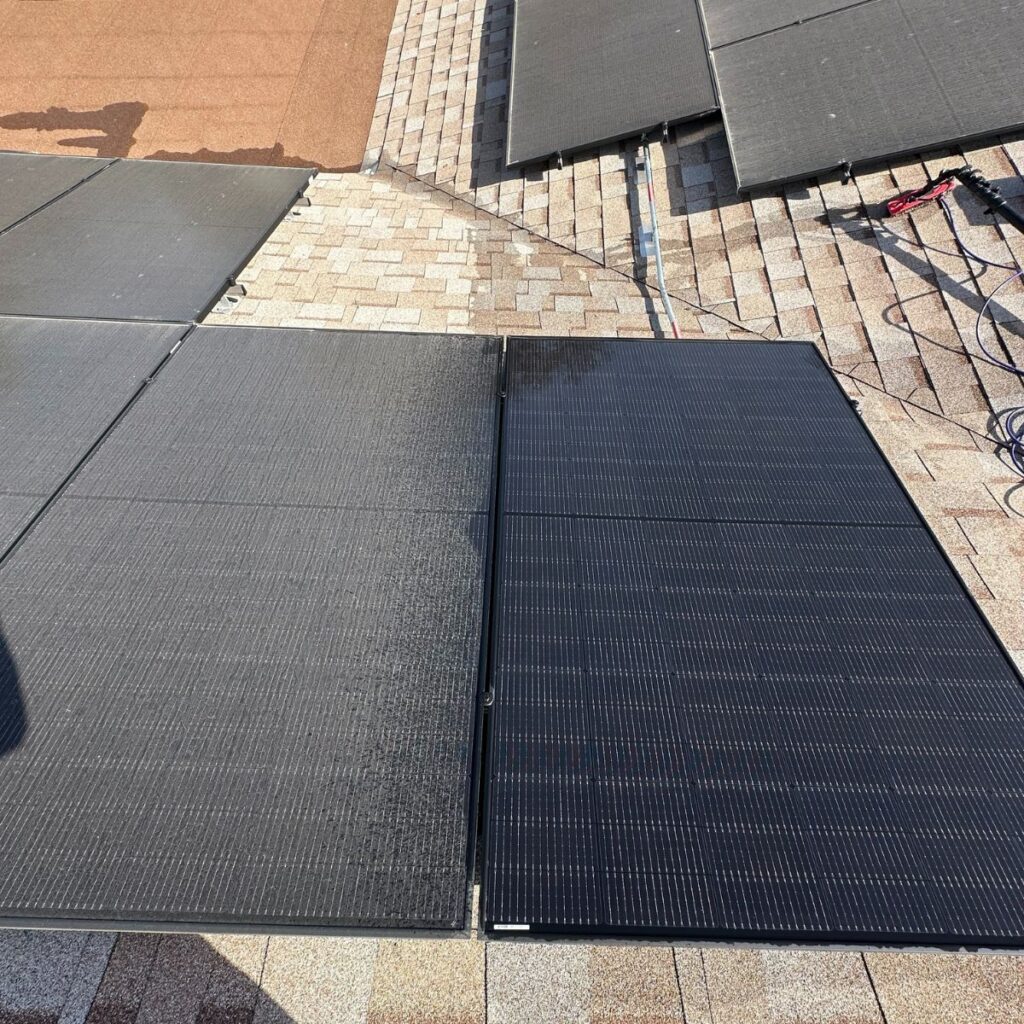 Close-up view of solar panels on a shingle roof, showing a distinct difference between cleaned and uncleaned panels